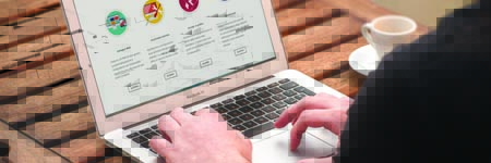 Hands typing on a laptop keyboard.