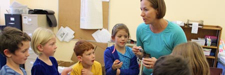 Parent volunteer leading an after-school science workshop.