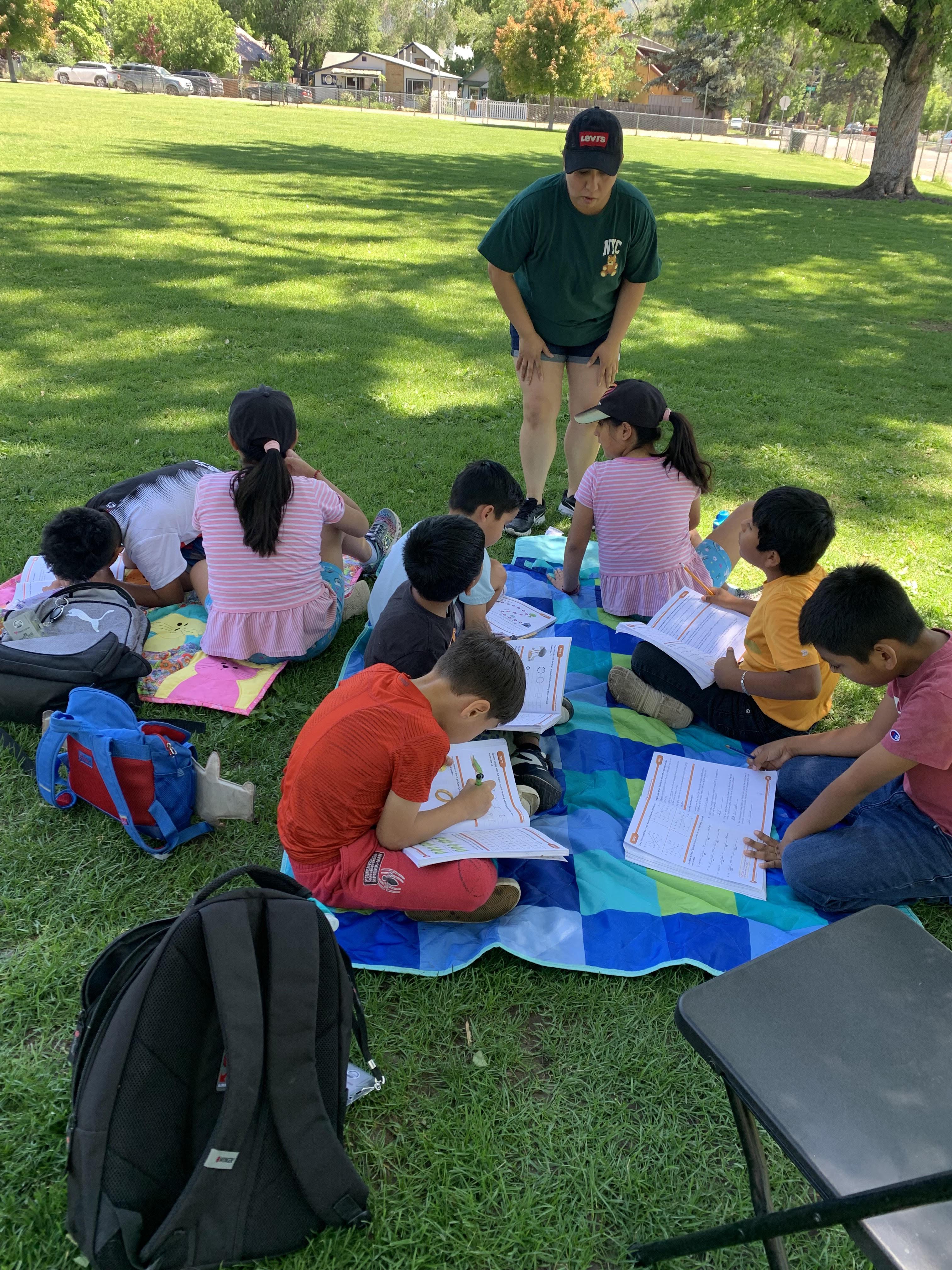 several students reading books in park