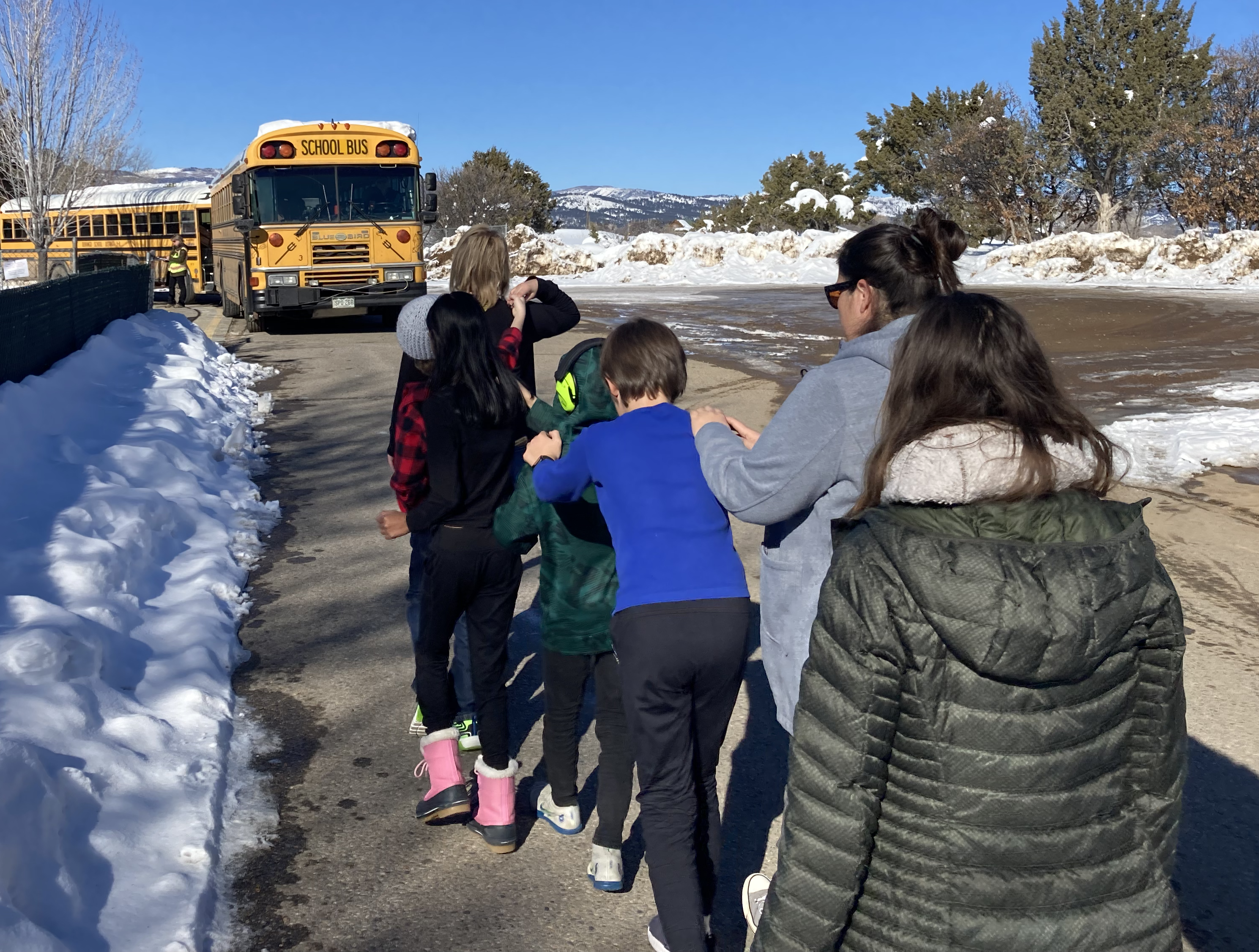 students walk in line to bus
